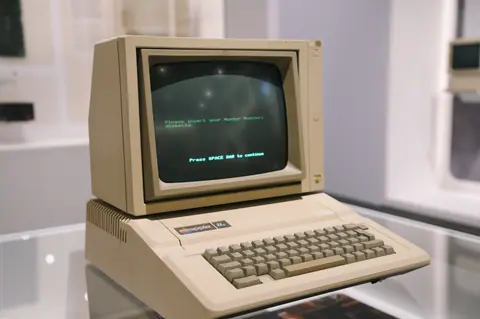 Retro Apple II computer in a museum setting, showcasing vintage technology design.