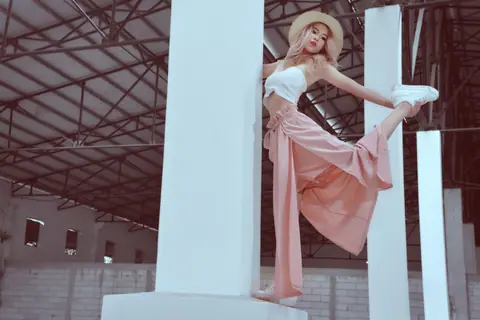 Fashionable woman striking a pose indoors in an industrial building, Phnom Penh.