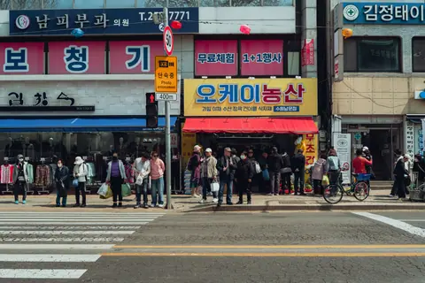 A bustling street scene in Seoul, South Korea, showcasing pedestrians and storefronts.