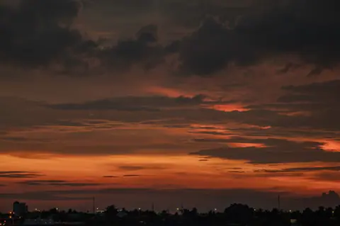 Breathtaking sunset above Cao Lãnh cityscape with dramatic clouds.
