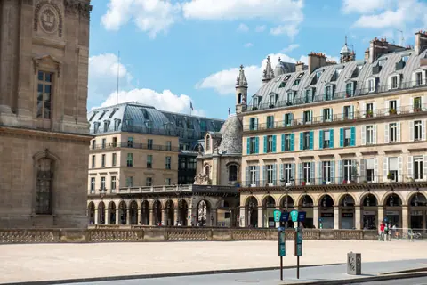 A classic Parisian street view featuring ornate buildings and a clear sky.