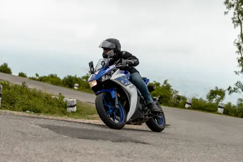 Motorcyclist expertly navigates a bend on a scenic road, showcasing speed and control.