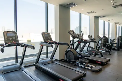 Spacious gym in Dubai equipped with modern treadmills and exercise bikes.