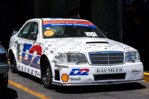 A parked vintage racecar with sponsor logos and a sleek design. Perfect for racing enthusiasts.