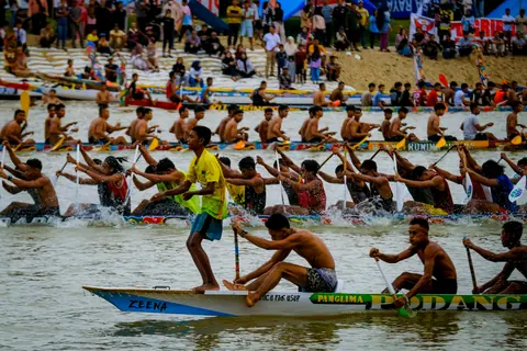 Energetic dragon boat race during a vibrant festival in Riau, showcasing teamwork and endurance.