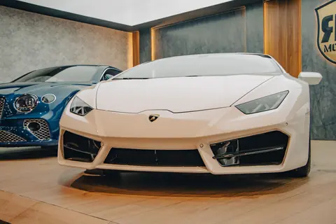 Close-up of a white Lamborghini on display in a luxury automotive showroom.
