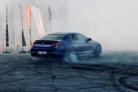 BMW M6 drifting at a smoky automotive event in Türkiye. Energetic and thrilling display.