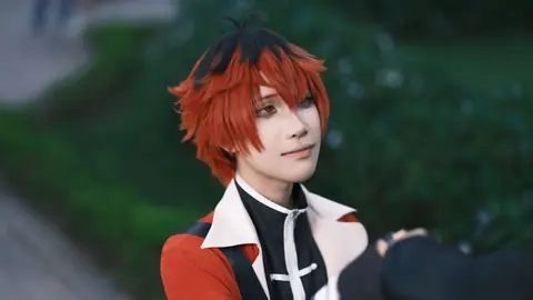 A cosplayer with red hair in a stylish outfit captured in a serene outdoor setting.