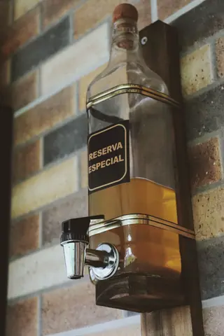 Elegant whiskey dispenser mounted on a brick wall, ideal for bars or home decor.