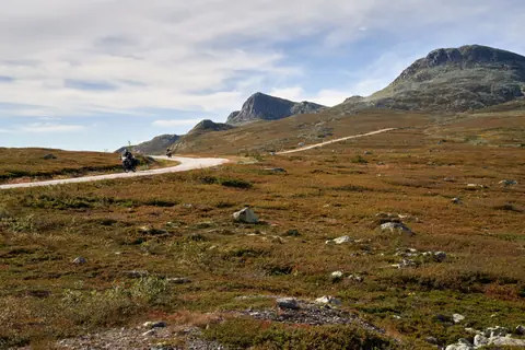 Two motorcyclists enjoy a scenic ride in Gaustatoppen, Telemark, Norway's stunning landscape.