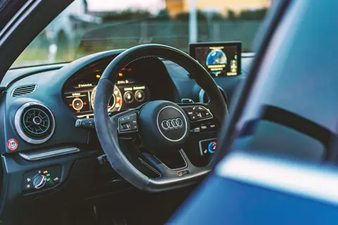 Explore the luxury Audi car interior featuring a sleek steering wheel and advanced dashboard display.