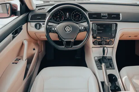 Explore the elegant and modern interior design of a Volkswagen Passat, showcasing the steering wheel and dashboard.