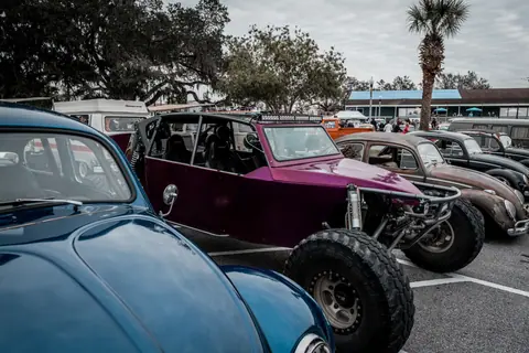 Custom beach buggy and vintage Volkswagen cars at an outdoor car event.