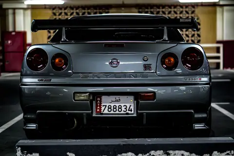 Rear view of a Nissan Skyline GT-R parked in an indoor urban parking lot.