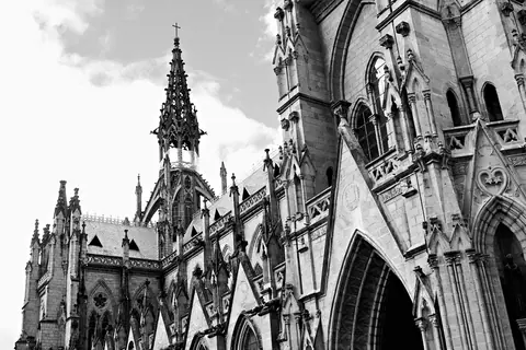 Black and white photo capturing the intricate Gothic architecture of a cathedral.