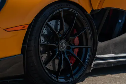 Detailed view of a black sports car wheel with carbon ceramic brakes in Illinois.