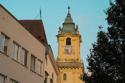 Capture of Bratislava's iconic clock tower with clear evening sky.