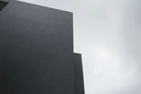 A striking minimalist facade in Istanbul contrasts against a cloudy sky.
