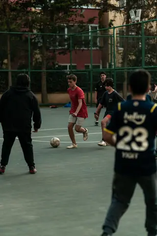 A group of teenagers playing soccer on an outdoor court in İstanbul, Turkey.