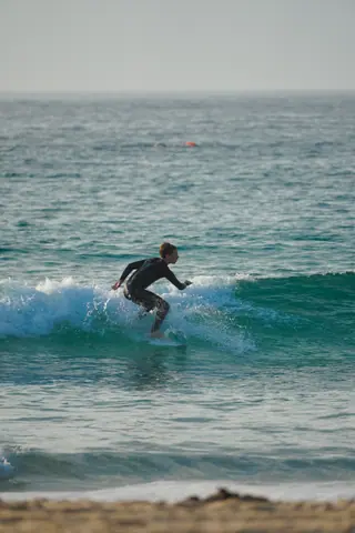 A young surfer catching a wave in the ocean, showcasing skill and balance.