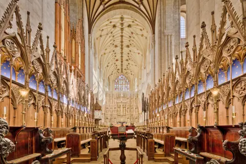 Explore the intricate Gothic architecture inside Winchester Cathedral showcasing stunning arches and carvings.