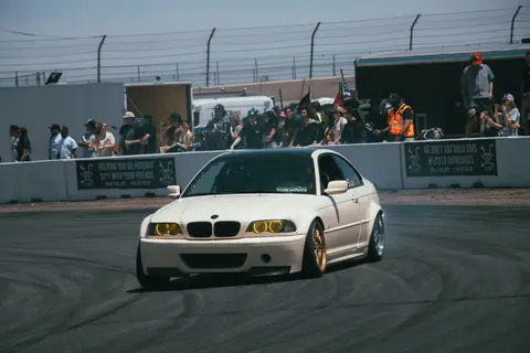 BMW car drifting on track with audience, showcasing drifting skills and race excitement.