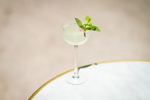 Elegant cocktail with mint garnish in a glass on marble, perfect for summer refreshment.