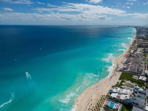 A breathtaking aerial view of Cancun's turquoise waters and sandy beaches lined with hotels.