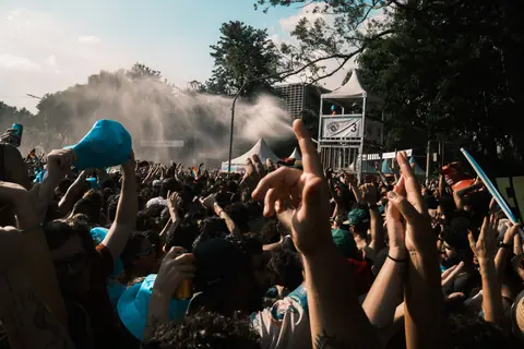 Vibrant crowd enjoying an outdoor music festival on a sunny day.