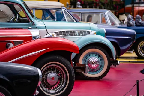 Vibrant display of vintage cars showcasing various classic designs at an auto show.