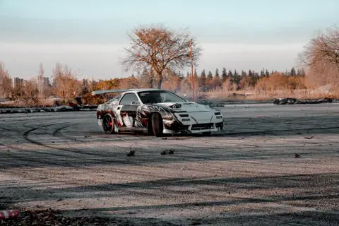 A sports car executing an intense drift maneuver in an open outdoor setting in Turkey.