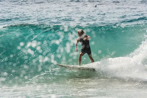 A surfer riding the vibrant waves at Coolangatta Beach in Queensland, Australia.