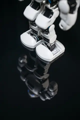 High-tech robot feet reflecting on a glossy surface, showcasing futuristic design.