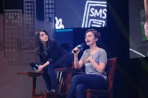 Hannah Alper and Lily Collins on stage at We Day Seattle 2015