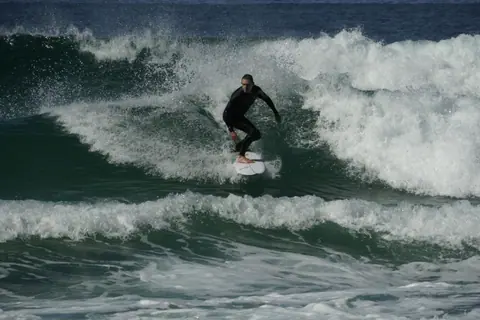 Surfer skillfully riding waves at iconic Bondi Beach in Australia.