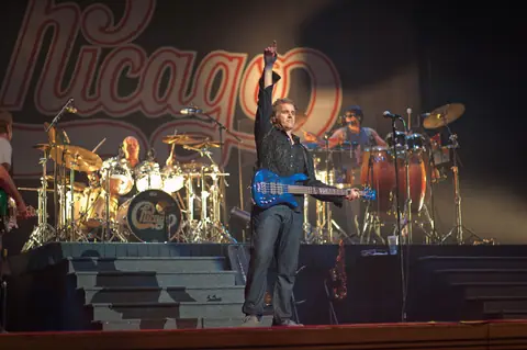 Energetic live concert show featuring musicians performing with drums, guitar, and bass.