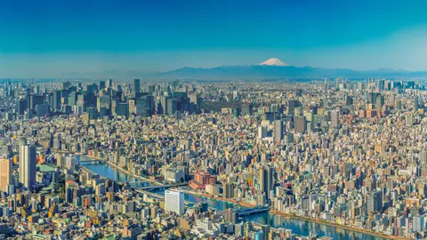 Panoramic view of Tokyo cityscape with Mount Fuji in the distance.