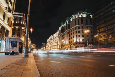 Urban night scene with long exposure of traffic lights and lit buildings.