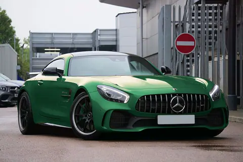 Luxury green Mercedes-AMG GTR sports car parked on a city street in the UK.