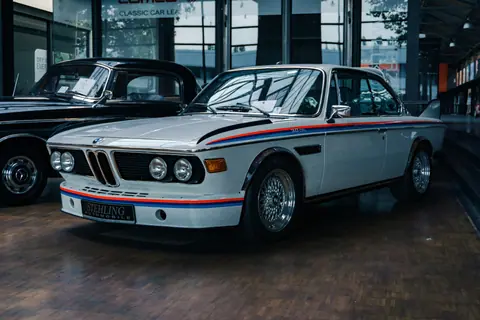 Showcase of vintage cars in an indoor exhibit, emphasizing classic design and automotive history.