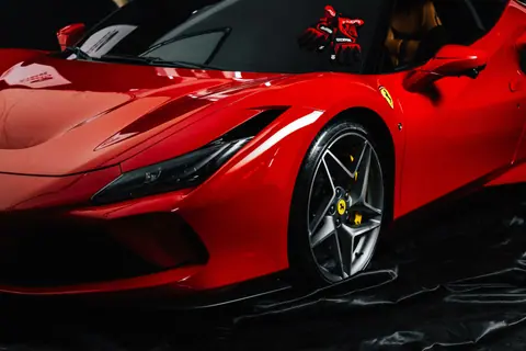 Close-up shot of a sleek red sports car with branded gloves on the dashboard. Ideal for luxury automotive themes.