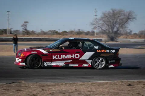 Captivating shot of a BMW E36 performing a drift on a motorsport circuit. Perfect for racing enthusiasts.