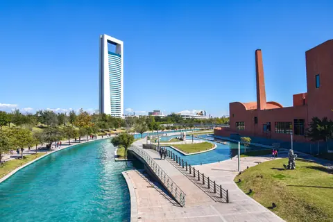 Scenic view of urban park in Monterrey, featuring a canal, modern architecture, and a towering skyscraper