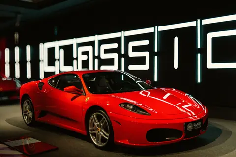 Vibrant red sports car displayed in a modern and stylish showroom with classic design.
