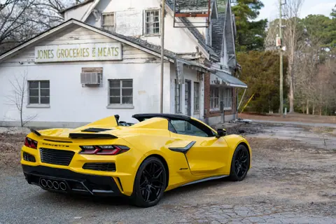 Vibrant yellow Corvette Z06 parked in front of an abandoned store in the USA.