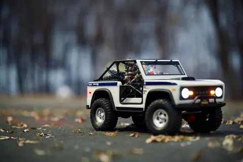 Detailed image of a miniature toy off-road vehicle on an autumn outdoor setting.