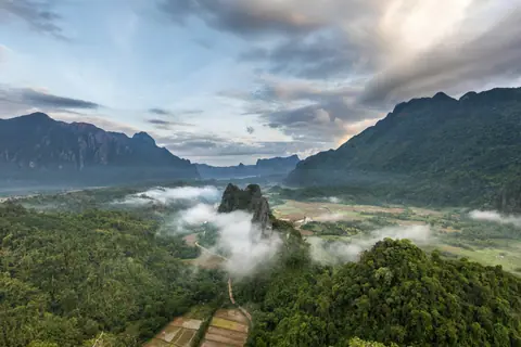 Karst peaks mist and colorful clouds at sunrise seen from Mount Nam Xay in Vang Vieng Laos