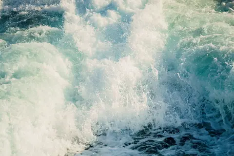 Dynamic capture of ocean waves crashing with white foam, showcasing the power and beauty of the sea.
