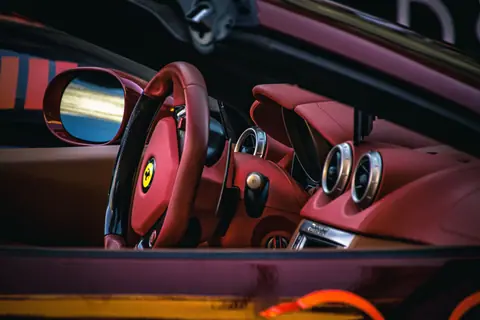 Close-up of a luxury sports car interior showcasing red leather seats and steering.