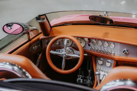 Explore the luxurious and classic interior design of a vintage convertible car featuring leather seats and intricate dashboard details.